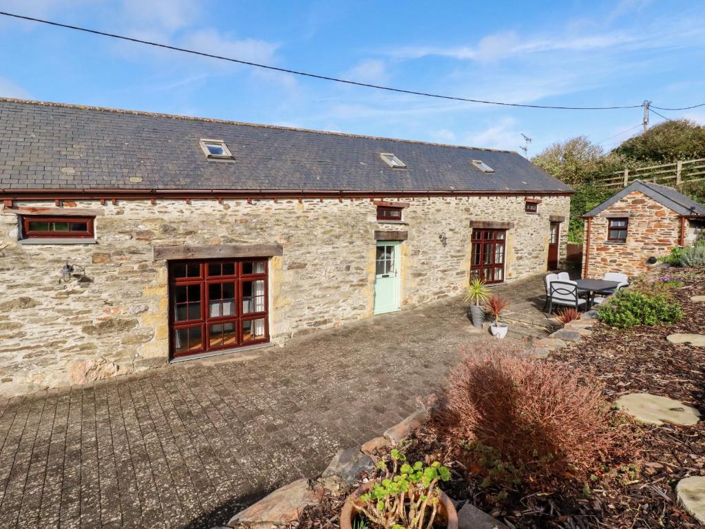 a stone house with a courtyard in front of it at Great Meadow Barn in Newquay