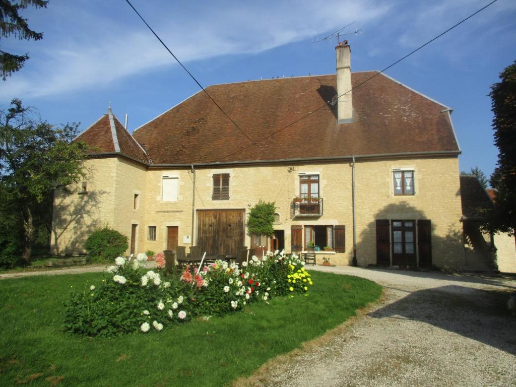 une grande maison en briques avec des fleurs dans la cour dans l'établissement Appartement La petite Résie, à La Résie-Saint-Martin