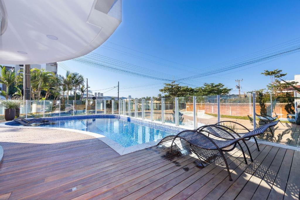 una terraza con 2 sillas y una piscina en Puntarenas 304 - Excelente cobertura duplex 2 suítes - Finamente mobiliada e decorada - À poucos metros da praia, en Bombinhas