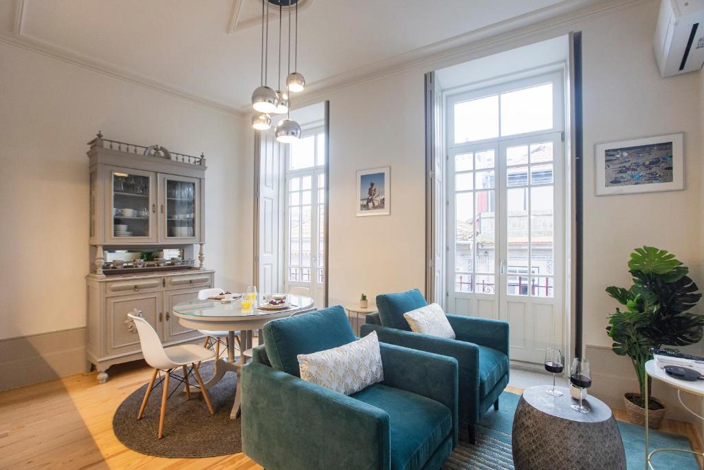 a living room with blue chairs and a table at Alma do Porto - With AC in Porto
