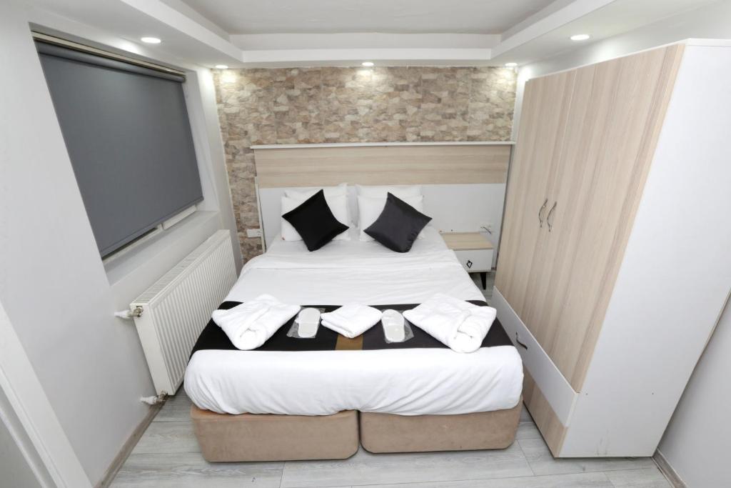 een kleine slaapkamer met een bed met witte lakens en kussens bij MİLA SUİTES TAKSİM in Istanbul