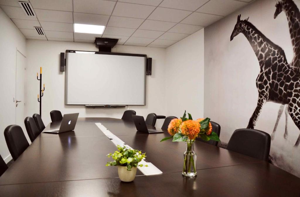 a conference room with a table and giraffes on the wall at Hôtel Toujours &amp; Spa in Paris