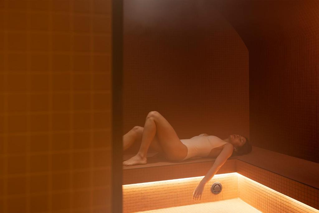 a model of a woman laying on a ledge in a bath tub at Hôtel Toujours &amp; Spa in Paris