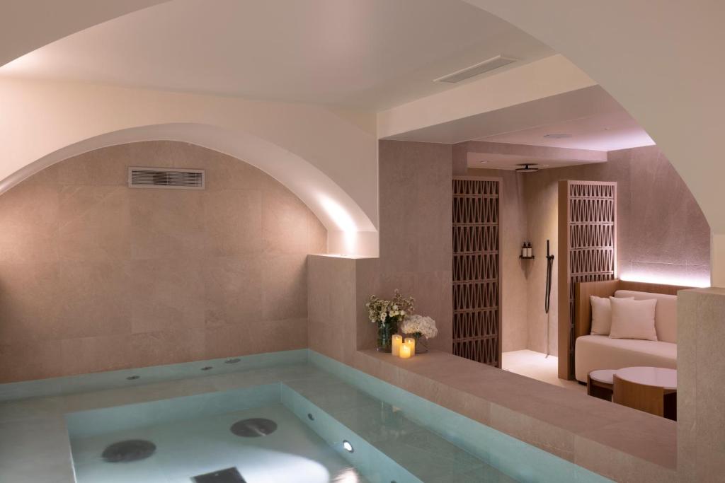 a bath tub in a room with a living room at Hôtel Toujours & Spa in Paris