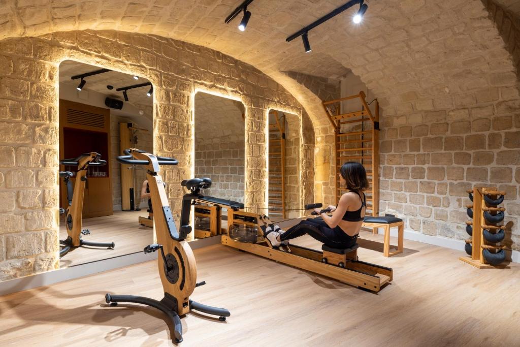 a woman exercising on a treadmill in a gym at Hôtel Toujours &amp; Spa in Paris