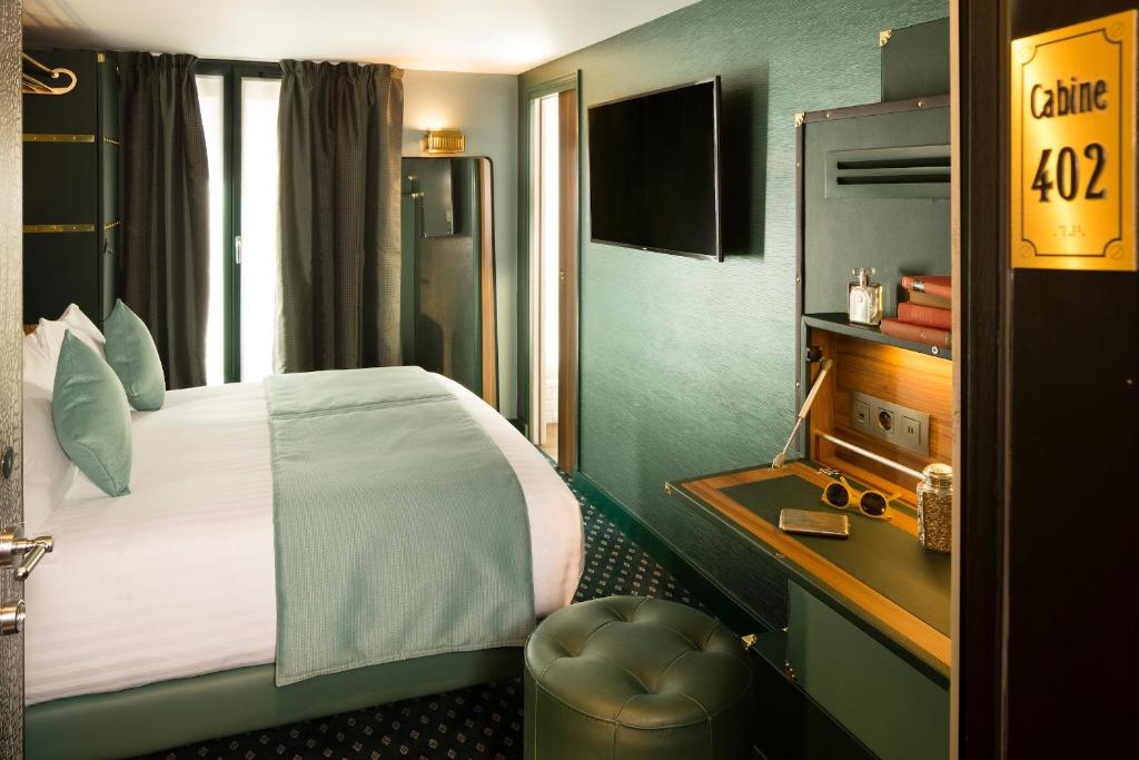 a hotel room with a large bed and a desk at Hotel Whistler - Gare du Nord in Paris