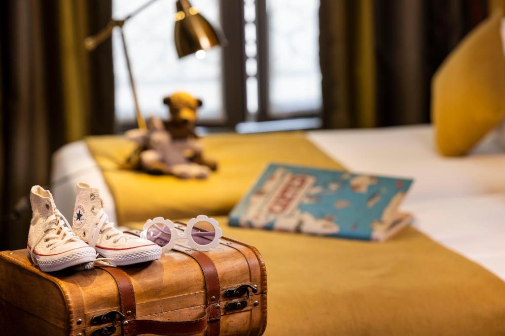 a pair of shoes sitting on a suitcase on a bed at Hotel Whistler - Gare du Nord in Paris