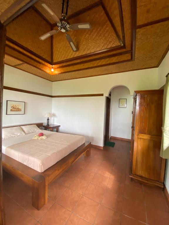 a bedroom with a bed and a ceiling fan at Geriasemalung in Tirtagangga