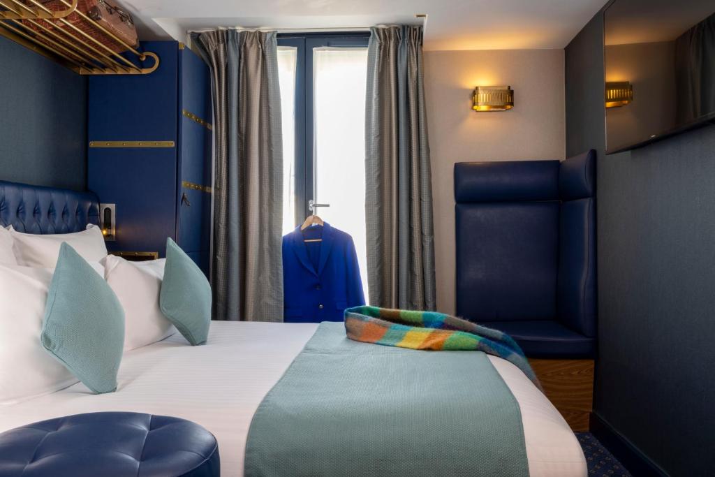 a hotel room with a bed and a chair at Hotel Whistler - Gare du Nord in Paris