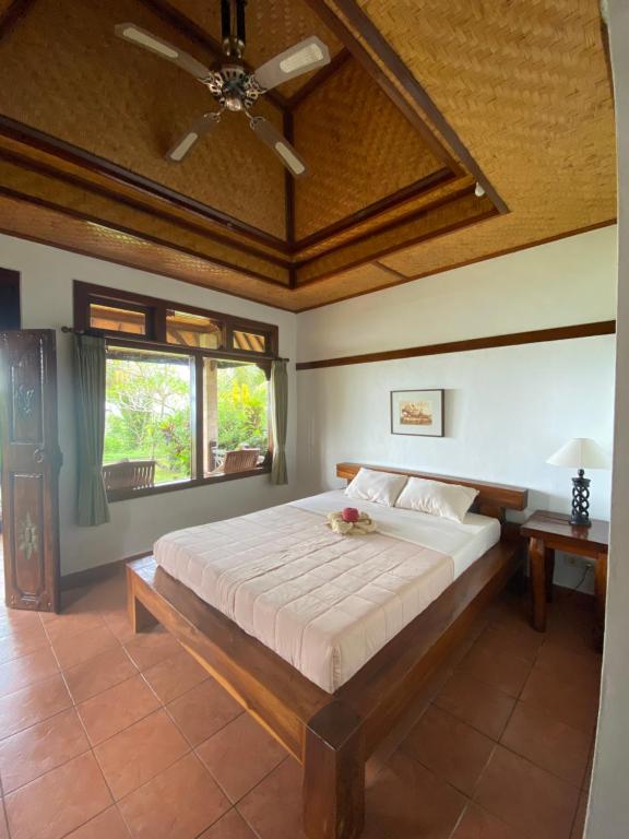 a bedroom with a large bed with a ceiling at Geriasemalung in Tirtagangga