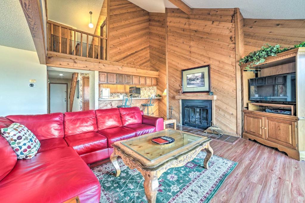 sala de estar con sofá rojo y mesa en Bellaire Resort Condo Ski, Tube, Explore!, en Bellaire