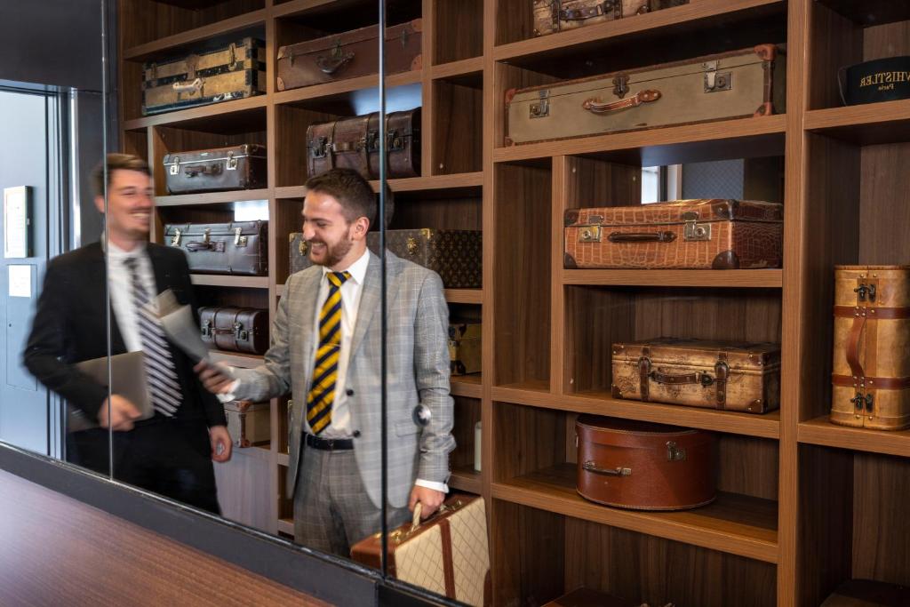 a man standing in front of a mirror in a store at Hotel Whistler - Gare du Nord in Paris