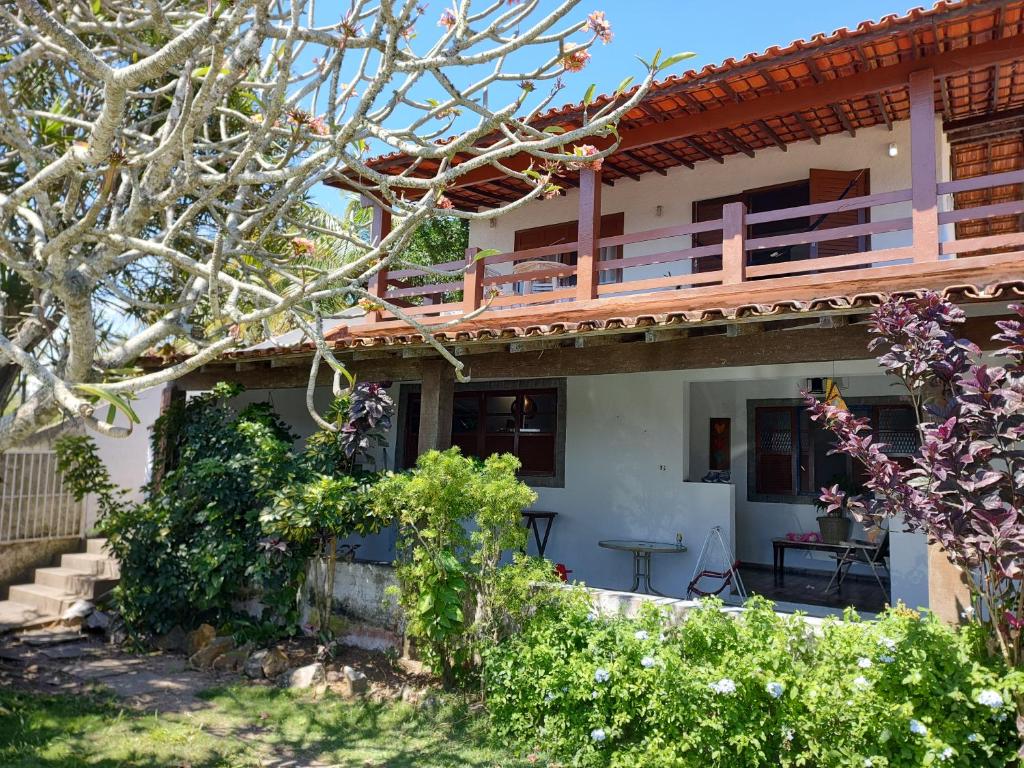 Elle offre une vue sur une maison dotée d'un balcon. dans l'établissement Casa pé na areia - 4m da praia!, à São Pedro da Aldeia