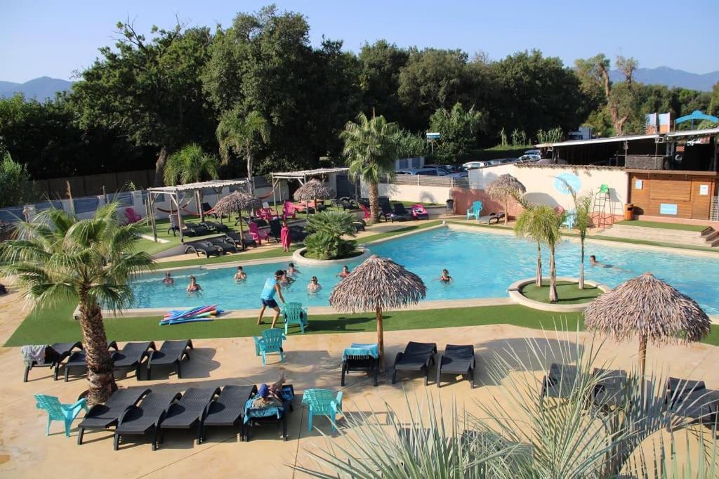a swimming pool with people in a resort at Camping Paradis Le Pearl in Argelès-sur-Mer
