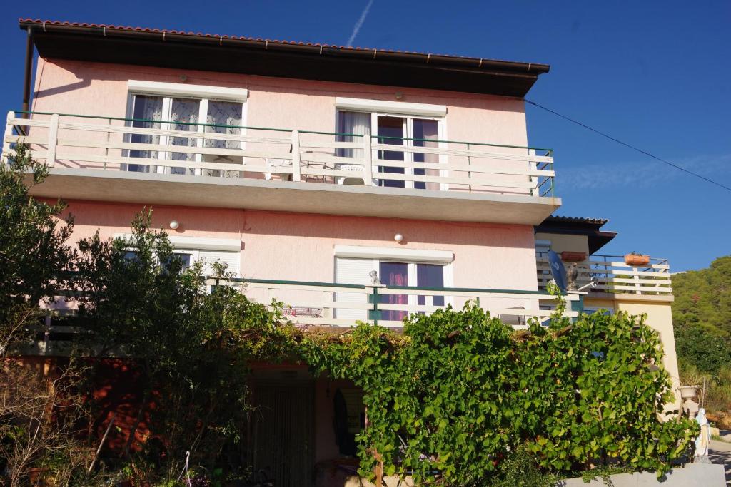 a building with a balcony on top of it at Apartments Opsenica Barbat in Barbat na Rabu