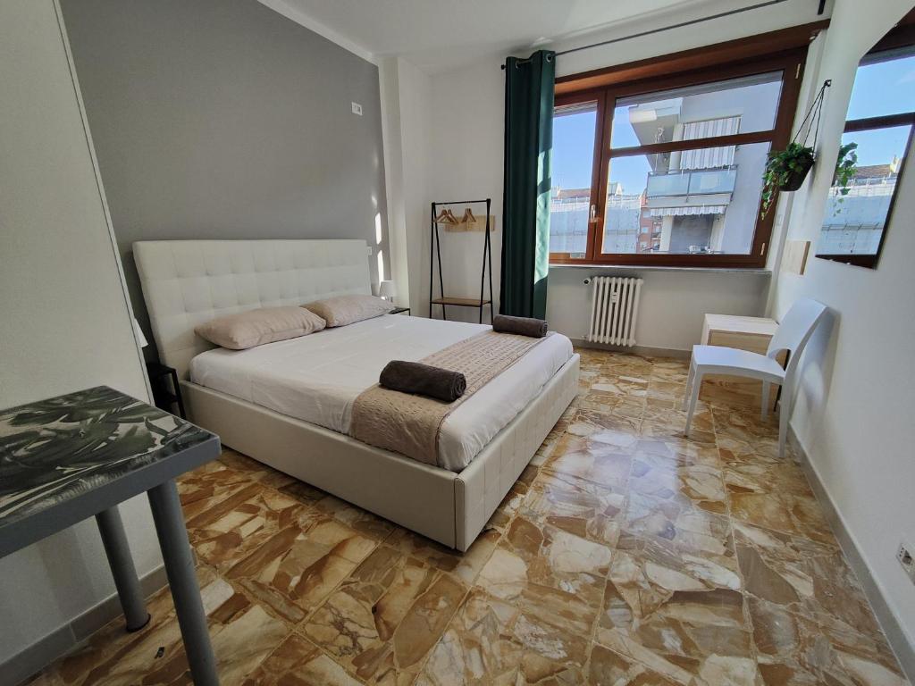 een slaapkamer met een bed, een tafel en een raam bij Affittacamere - Santa Rita Rooms in Turijn