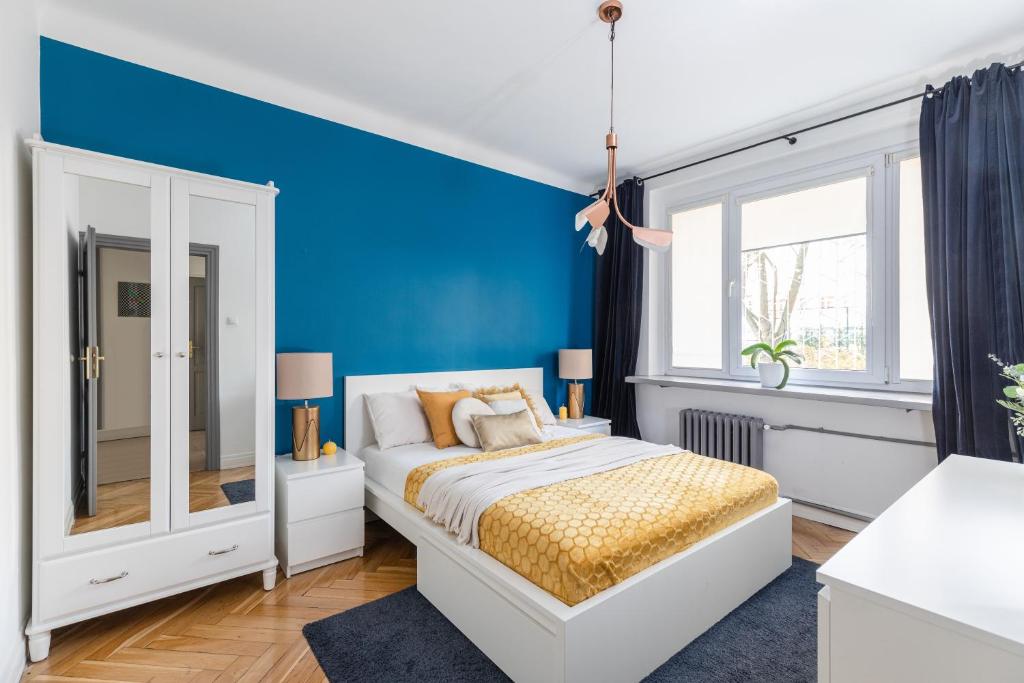 una camera da letto con una parete con accento blu e un letto di SuperApart Lewartowskiego 10 a Varsavia