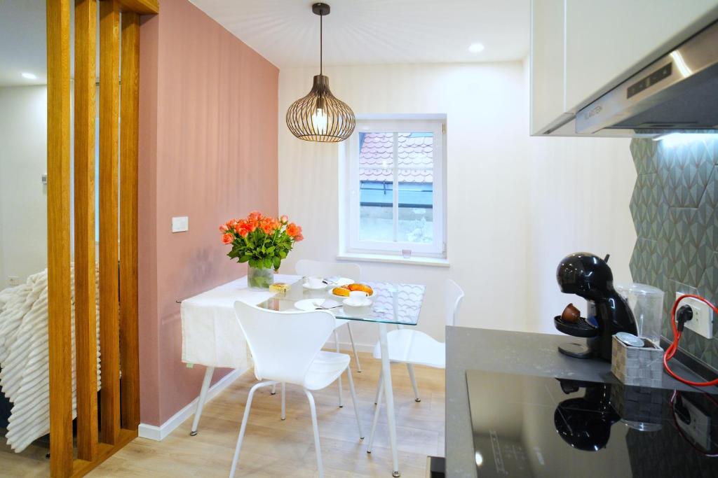a kitchen with a white table and white chairs at Sweet Stay Castle Apartment in Ljubljana