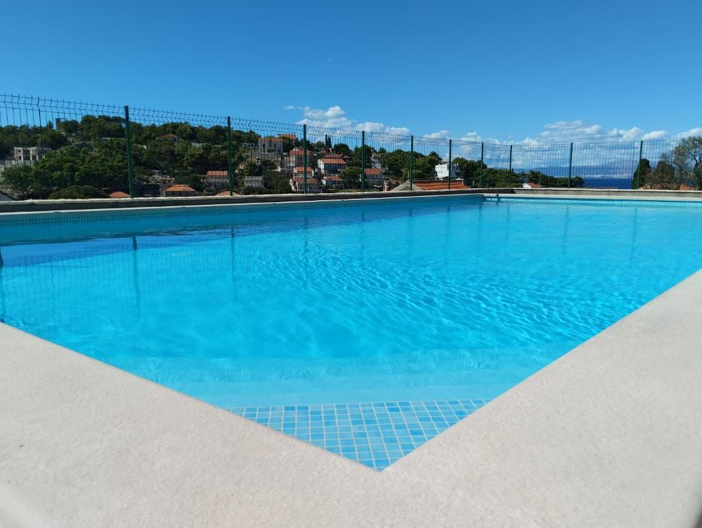 uma grande piscina com água azul em Villa Sanja, Splitska em Splitska