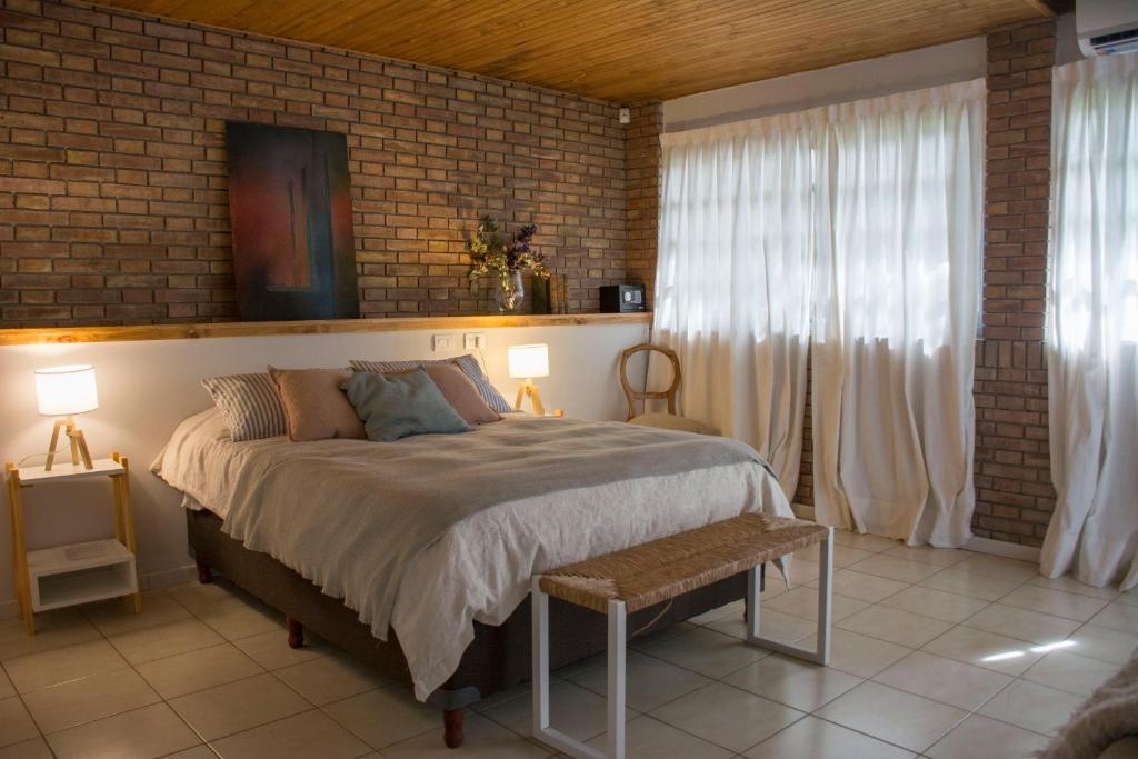 a bedroom with a bed and two lamps and a brick wall at Casa Reconquista in Mendoza
