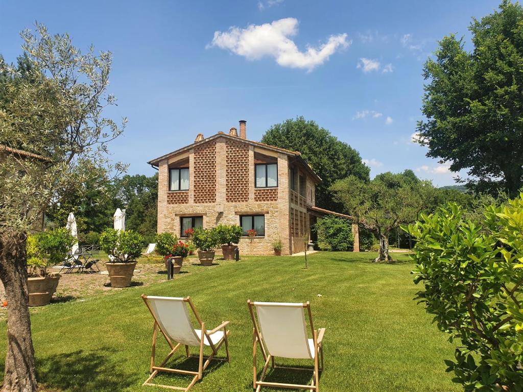 two chairs in the yard of a house at Agriturismo Podere La Fornace in Assisi