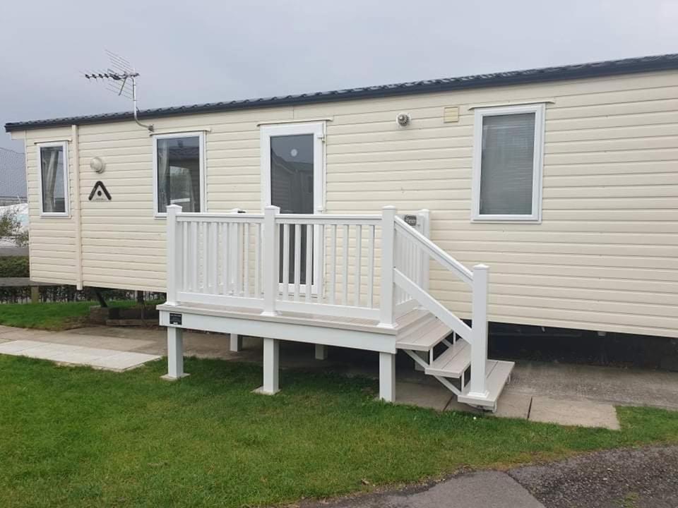 una casa con una escalera blanca junto a una casa en Littlesea Haven fleetview en Weymouth