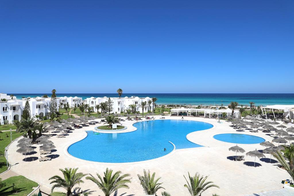 米多恩的住宿－文奇太陽神海灘酒店，享有带游泳池和海洋的度假村的空中景致