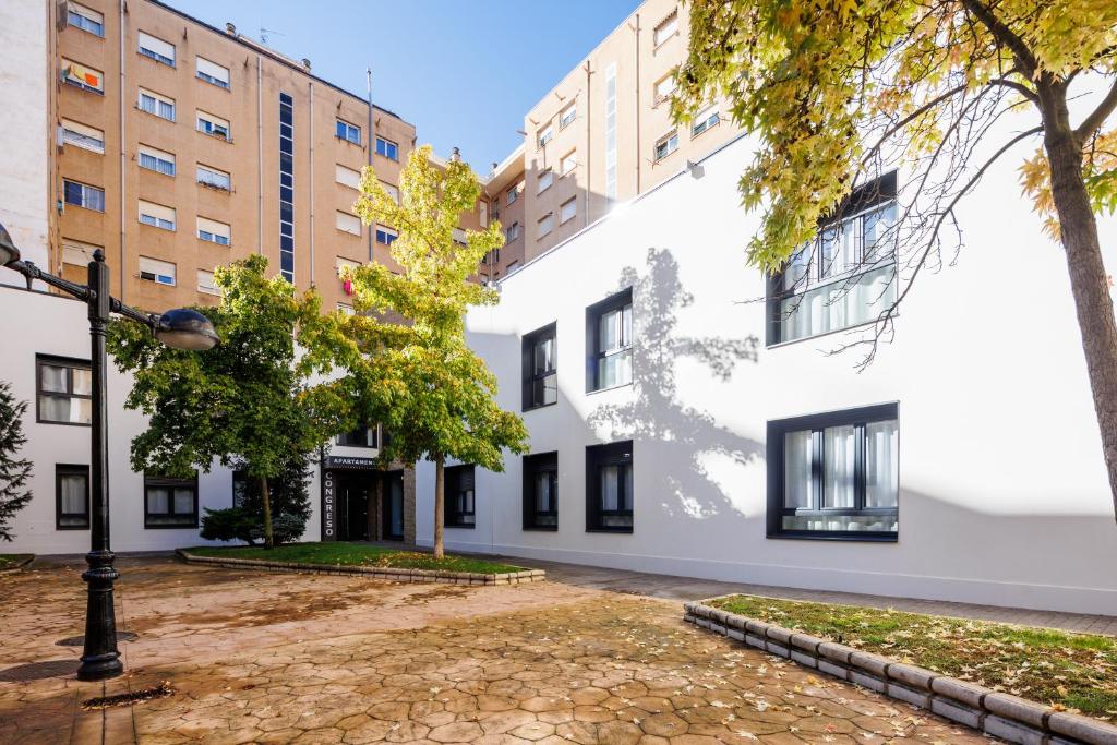 un edificio blanco con ventanas negras y luz de la calle en Apartamentos Congreso, Parking gratuito, en Logroño
