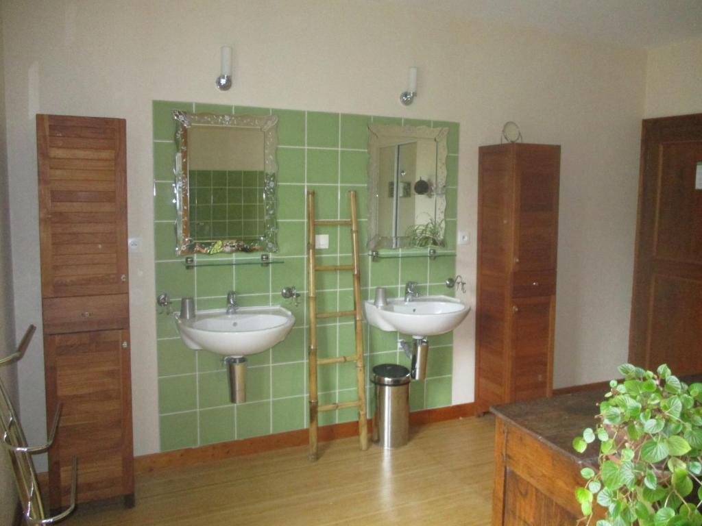 a bathroom with two sinks and a green tiled wall at Appartement La petite Résie in La Résie-Saint-Martin