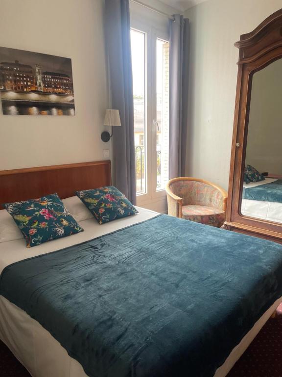 a bedroom with a bed with a blue blanket and a mirror at Hôtel Verlaine in Paris