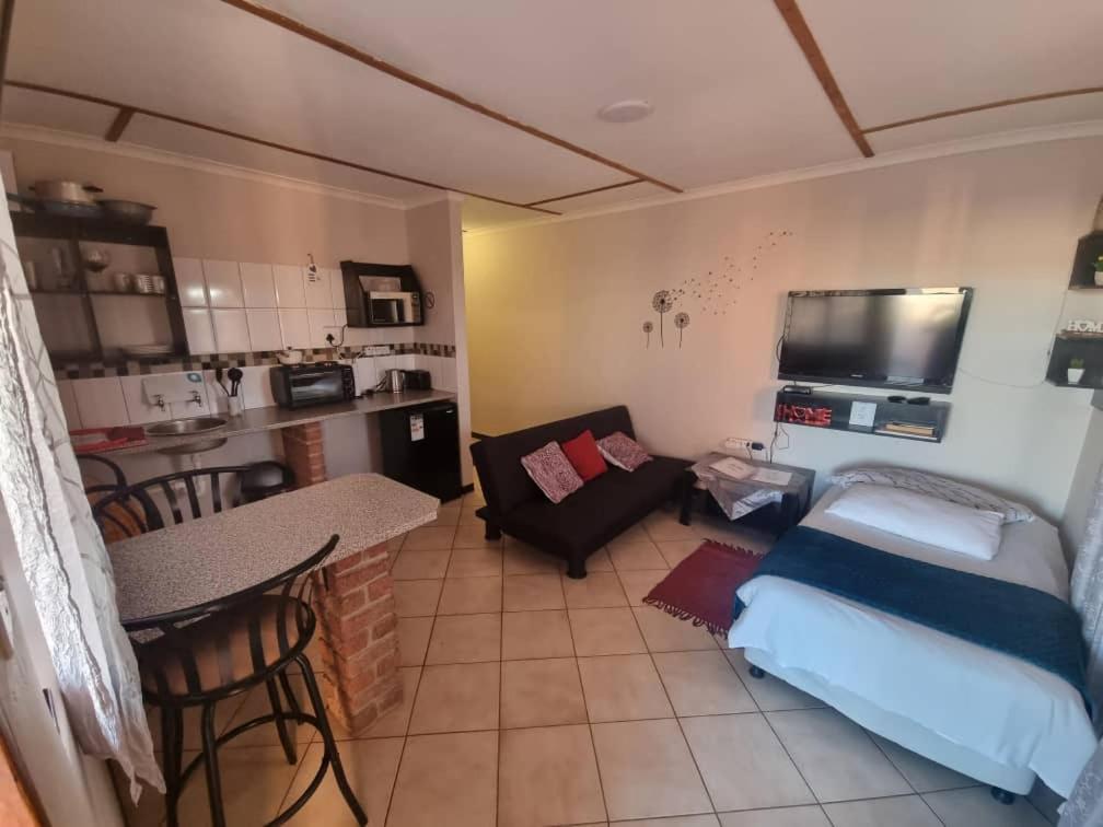 ein kleines Wohnzimmer mit einem Sofa und einer Küche in der Unterkunft Seabreeze Accommodation in Lüderitz