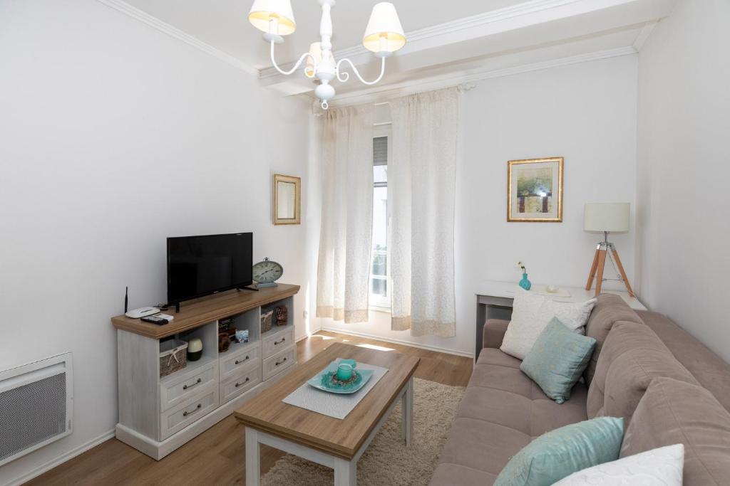 een woonkamer met een bank en een tv bij Happy Apartments Mostar in Mostar