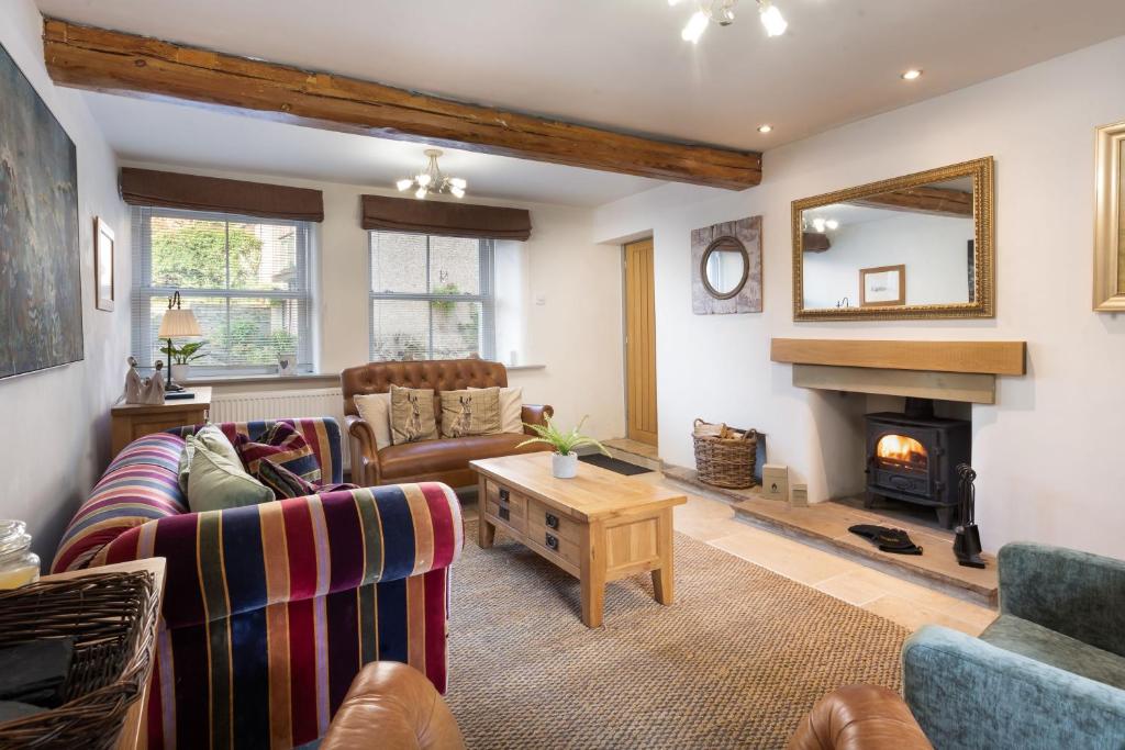 a living room with two couches and a fireplace at Pinewood Cottage - Newby Bridge in Lakeside