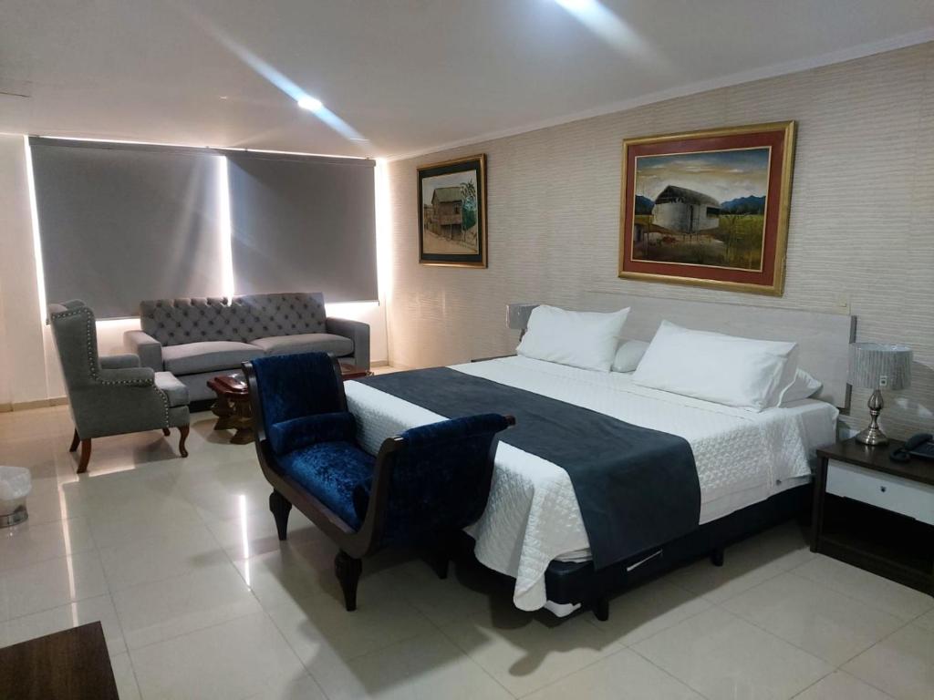 Habitación de hotel con cama grande y sofá en Hotel Ejecutivo Portoviejo, en Portoviejo