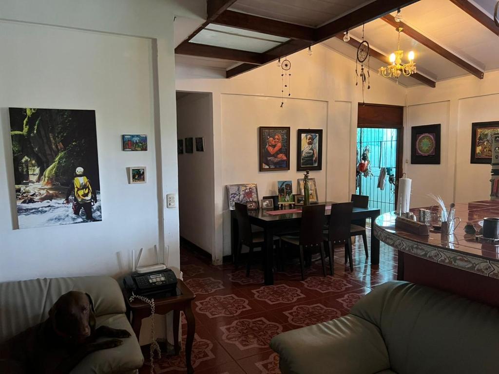 a living room with a couch and a dining room at Pure Canyoning Home in Turrialba