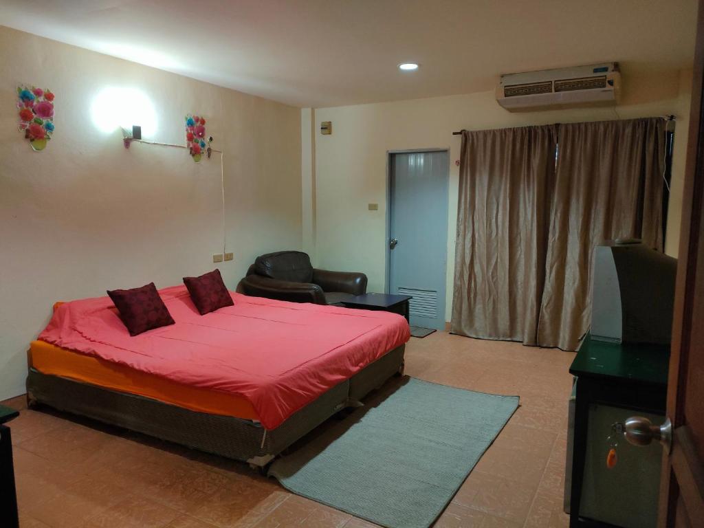 a bedroom with a red bed and a television at Anmol Hotel Thai Smile Group in Pattaya Central