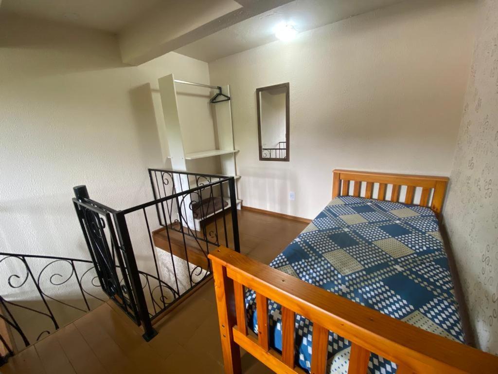 Habitación pequeña con cama y escalera en RESIDENCIAL BORGES CANELA, en Canela