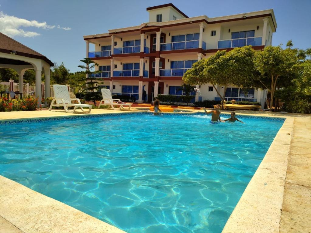 a swimming pool in front of a hotel at Madome Aparta Hotel in Pedernales