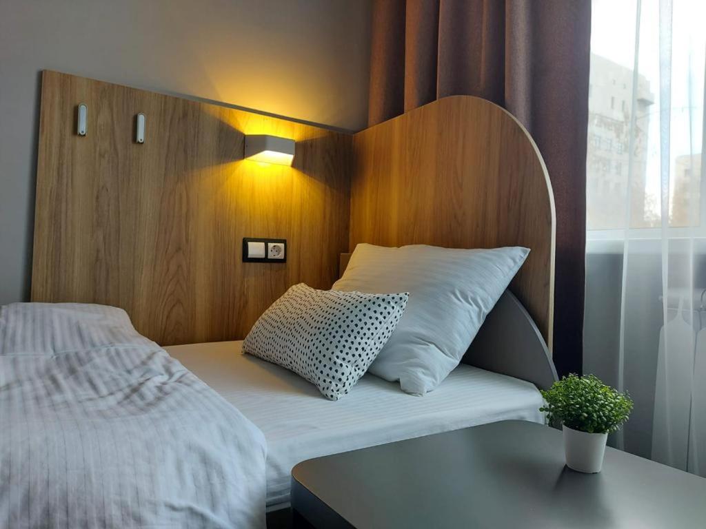 a bed with a wooden headboard with a pillow on it at Astra in Chelyabinsk