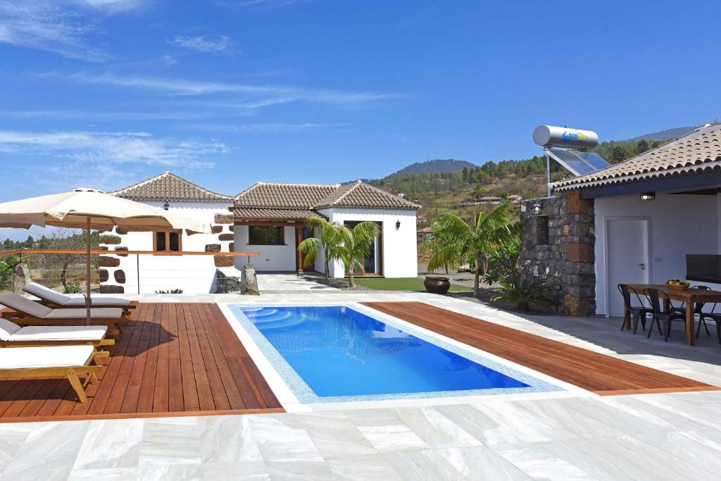 a villa with a swimming pool and a house at Casa La Florida in Puntagorda