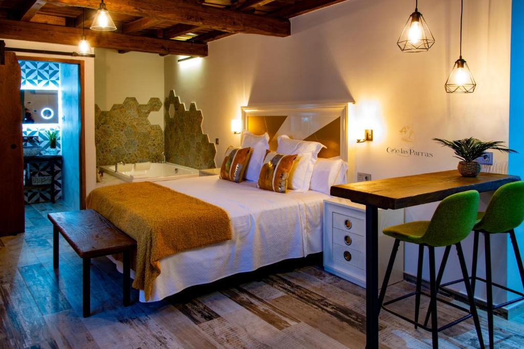 Apartamentos Caño las Parras في إرفاس: غرفة نوم مع سرير ومكتب وحوض استحمام