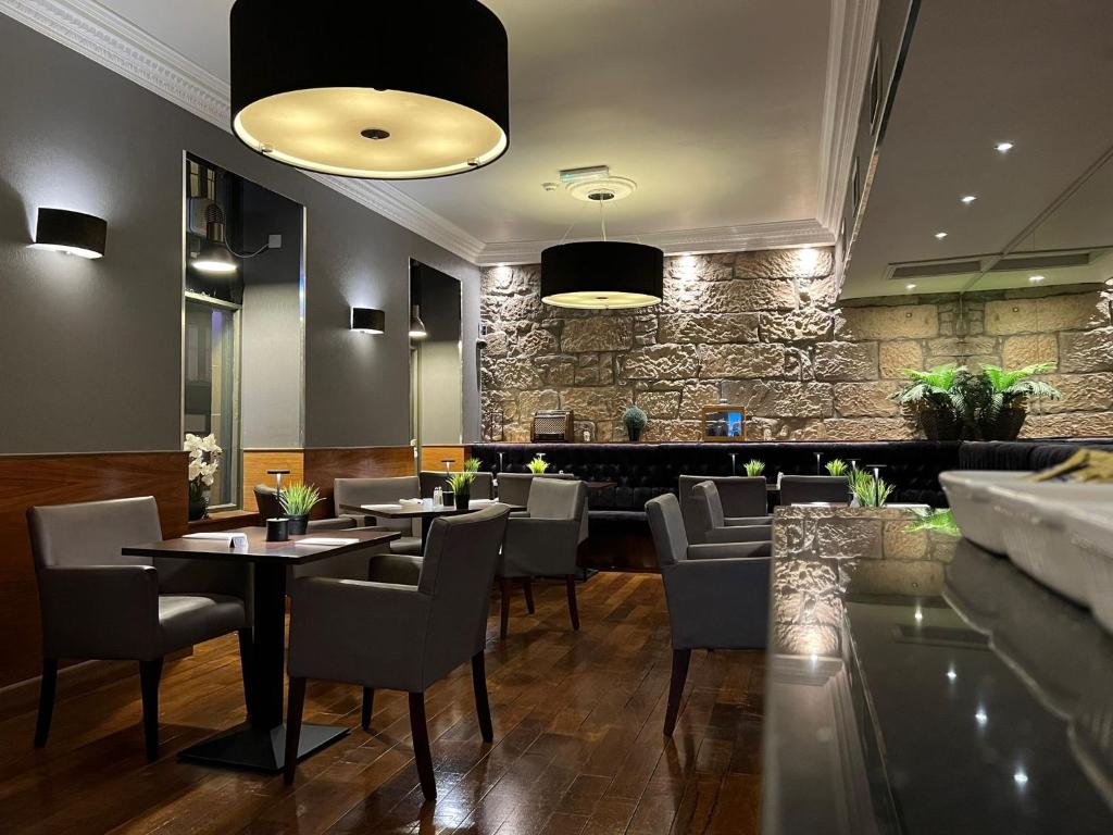 ein Restaurant mit Tischen und Stühlen und einer Steinmauer in der Unterkunft Best Western Glasgow Hotel in Glasgow