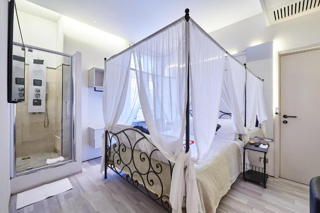 a bedroom with a canopy bed and a shower at Room 230 Roma Luxury Suites in Rome