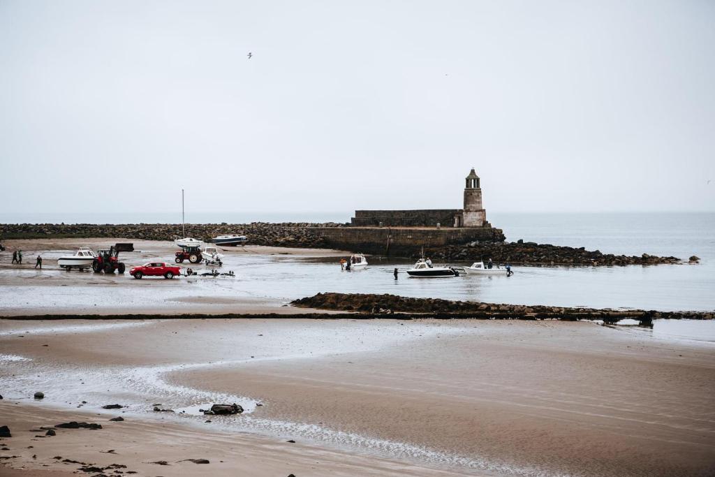 a view of a beach with a lighthouse in the background at Curlew Cottage and Sunset View 