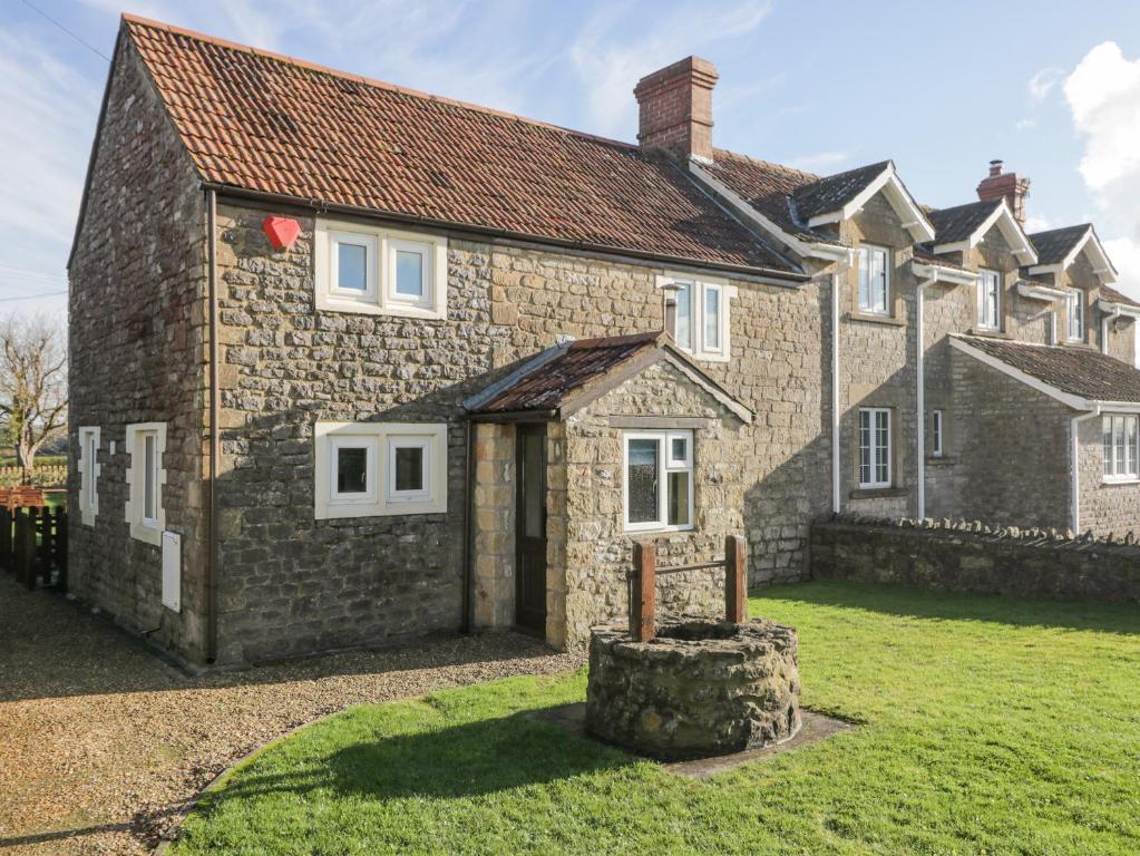 une vieille maison en pierre avec une cour devant elle dans l'établissement 26 Tansey, à Shepton Mallet