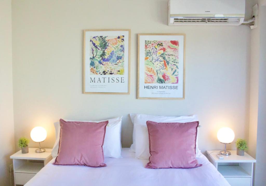 1 dormitorio con 2 posters en la pared y 1 cama con almohadas rosas en Recoleta Apartment Amazing view -13A- en Buenos Aires