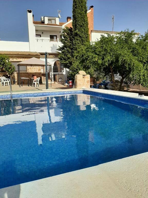 une grande piscine bleue en face d'un bâtiment dans l'établissement Horizontes de La Mancha, à El Toboso