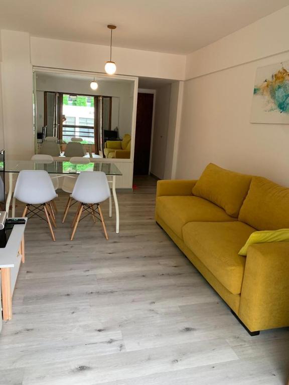 Excelente departamento de dos ambientes en Playa Grande Mar del Plata في مار ديل بلاتا: غرفة معيشة مع أريكة صفراء وطاولة