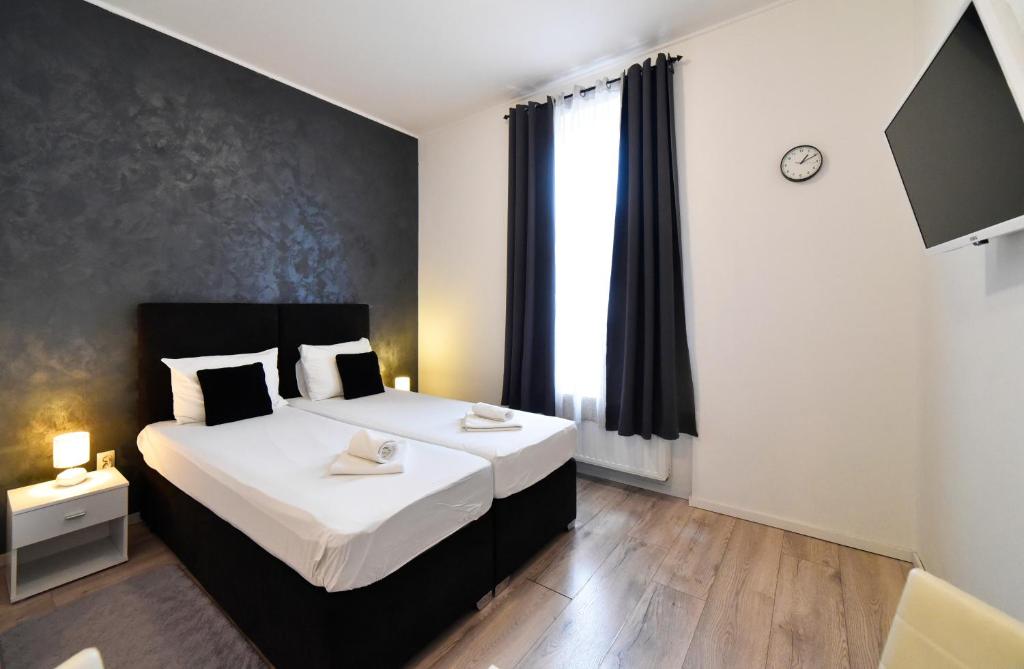 a bedroom with two beds and a large window at Virtus Apartments and Rooms with Free Private Parking in Zagreb