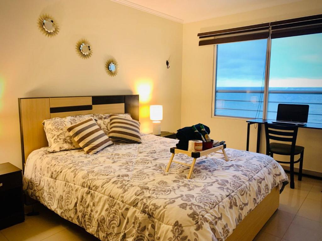 Vista al Mar في بلاياس: غرفة نوم مع سرير مع كلب يجلس على طاولة